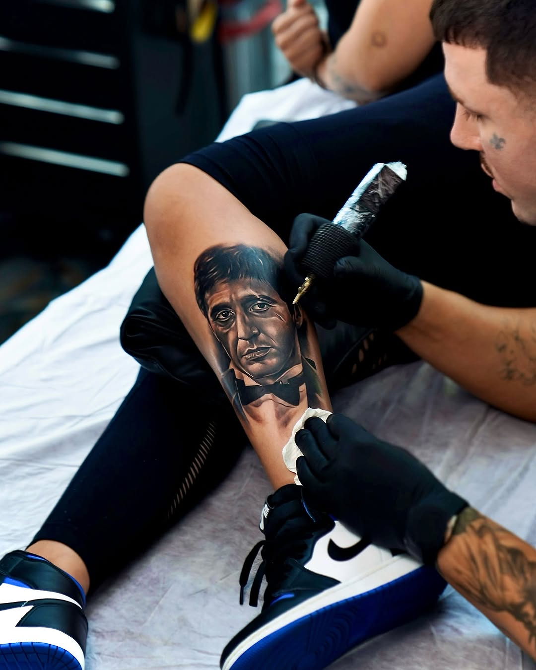 Kristian Vendler tattooing a realism portrait on a client's calf