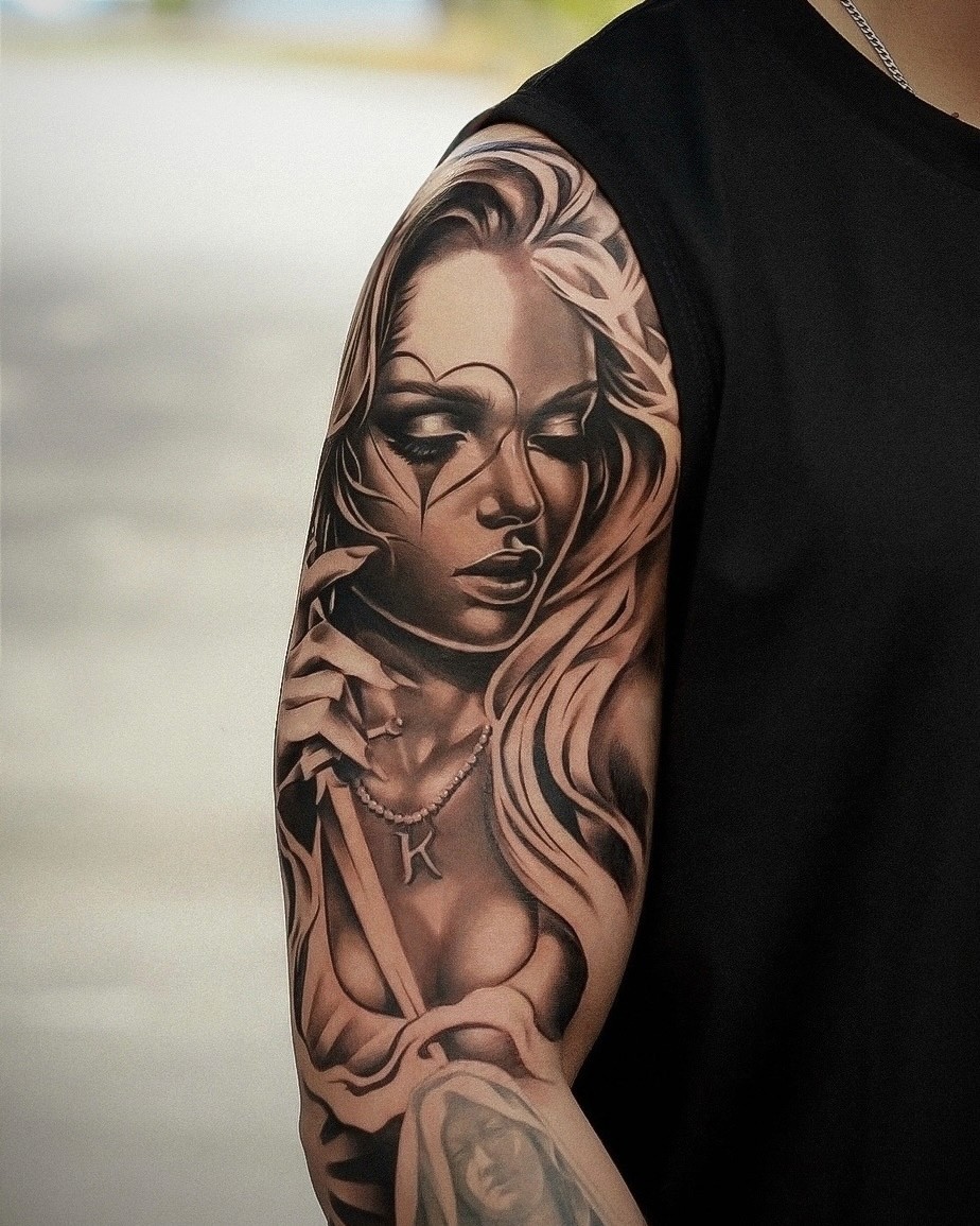 Black and grey chicano sleeve of a woman with clown tear makeup and Virgin Mary piece